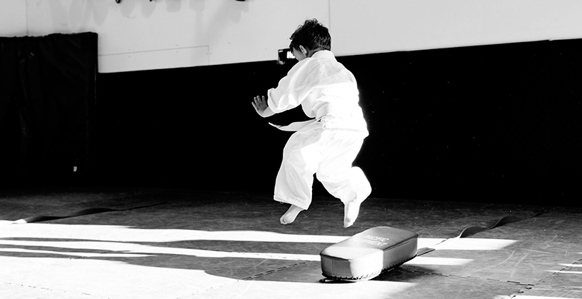 Small child training Brazilian Jiu Jitsu in a kimono